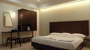 A modern hotel room with a large bed, a desk, and a wardrobe. - Flora Pavillion Near Global Hospital Perumbakkam (Chennai)