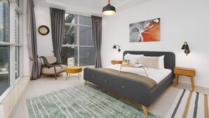 Ein modernes Schlafzimmer mit einem großen Bett, einem Sessel, einem kleinen Tisch und einem Fenster mit Vorhängen.