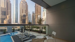 Ein Balkon mit Pool, Liegestühlen und Blick auf hohe Gebäude.