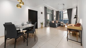 Ein modernes Wohnzimmer mit Essbereich, ausgestattet mit einer Couch, einem Couchtisch und einem Esstisch mit Stühlen.