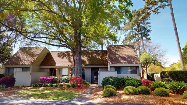 A two-story house with a front yard, a driveway, and a mailbox.