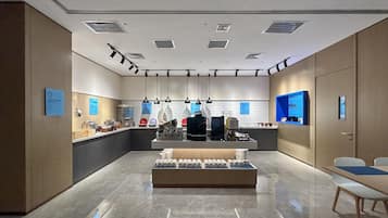 Un moderno interior de cafetería con mostrador, zona de estar y exhibición de productos.