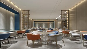 A modern interior with round tables, chairs, and bookshelves. - Holiday Inn Express Dandong City Center (Dandong)