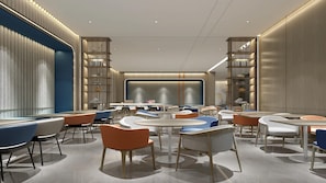 A modern interior with round tables, chairs, and bookshelves.