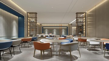 A modern interior with round tables, chairs, and bookshelves.