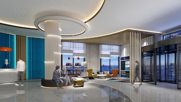 A modern lobby with a central column, seating areas, and large windows offering views.