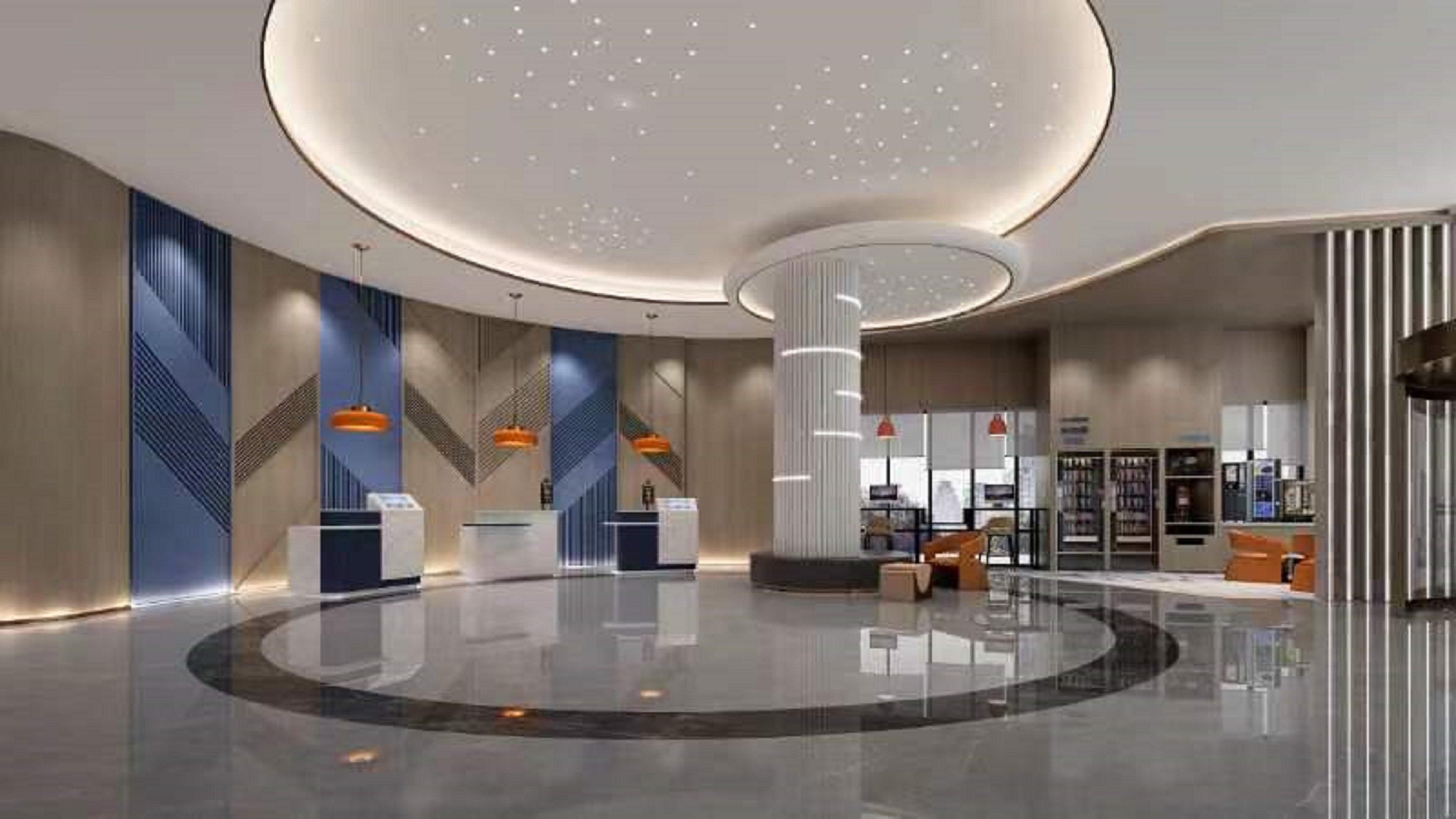 En moderne lobby med en rund receptionsdisk, en central søjle og et siddeområde med udsigt over indretningen.