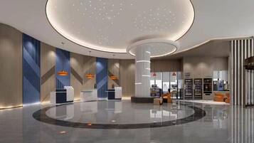 En moderne lobby med en rund receptionsdisk, en central søjle og et siddeområde med udsigt over indretningen.