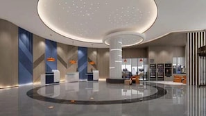 A modern lobby with a circular reception desk, a central column, and a seating area with a view of the interior. - Holiday Inn Express Dandong City Center (Dandong)
