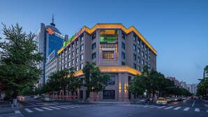 A multi-story hotel with a prominent entrance, large windows, and a modern architectural design. - Holiday Inn Express Dandong City Center (Dandong)