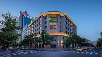 A multi-story hotel with a prominent entrance, large windows, and a modern architectural design.