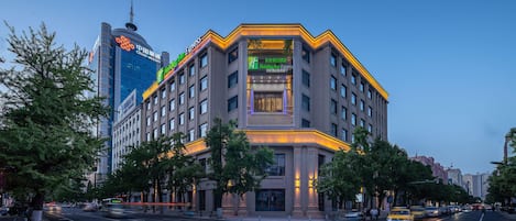 A multi-story hotel with a prominent entrance, large windows, and a modern architectural design.