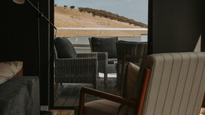 A room with wicker furniture and a view of a beach. - Tranmere Seaside Serenity (Tranmere)
