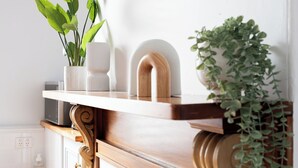 A kitchen counter with a microwave, a white vase, and a wooden spoon.
