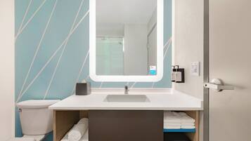 A bathroom with a white sink, a mirror, and a towel rack.