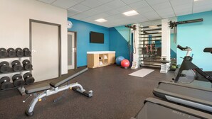 Egy edzőterem futópadokkal, súlyzókkal és fitneszlabdákkal.