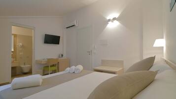 Une chambre d’hôtel avec un lit, une télévision, une salle de bain et un bureau.