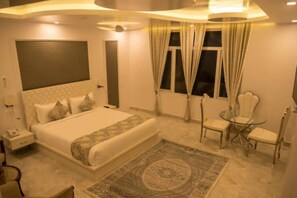 Una habitación de hotel moderna con una cama grande, una mesa de vidrio y una silla.