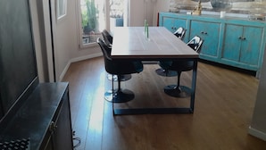 A dining area with a wooden table and chairs, a blue cabinet, and a sailboat model on a shelf. - Luxury 2 Bdr Duplex Apt with A.C. & Elevator, 2 Terraces & view on EIFFEL TOWER (Paris)