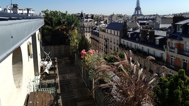 A rooftop terrace with a view of the Eiffel Tower, featuring a wooden deck, potted plants, and a metal railing. - Luxury 2 Bdr Duplex Apt with A.C. & Elevator, 2 Terraces & view on EIFFEL TOWER (Paris)