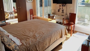 A bedroom with a large bed, a desk, a chair, a TV, and a sliding glass door to the outside. - Luxury 2 Bdr Duplex Apt with A.C. & Elevator, 2 Terraces & view on EIFFEL TOWER (Paris)