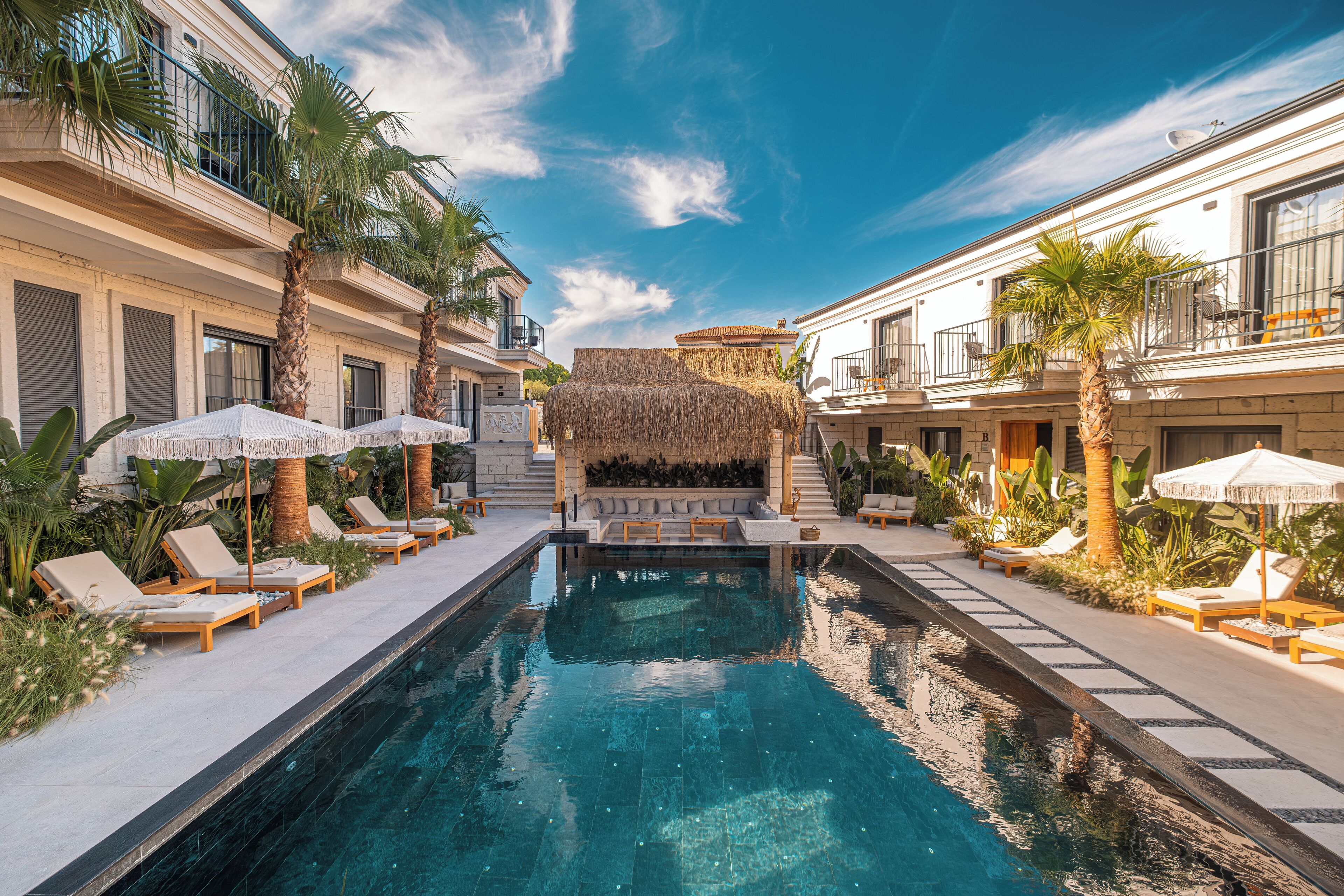 Una piscina al aire libre, sombrillas, tumbonas