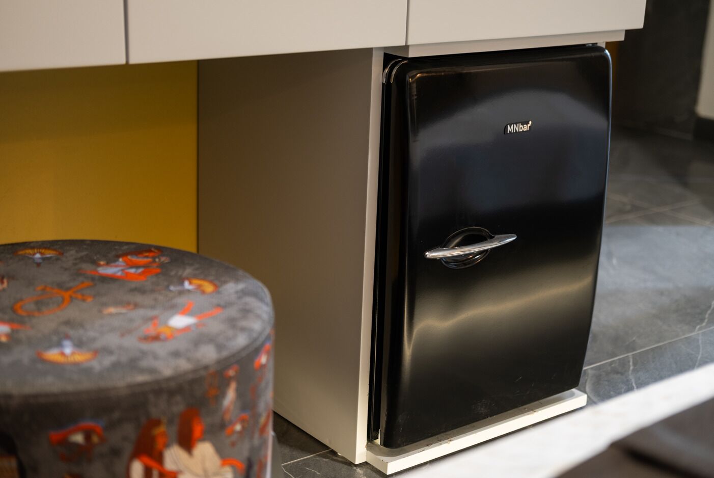 Un réfrigérateur noir de la marque MNbar®, placé dans une cuisine.