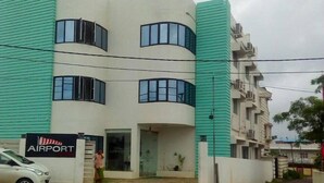 A modern building with a sign reading "AIRPORT" on the ground floor, indicating proximity to an airport. - Airport Hotel (Port Blair)