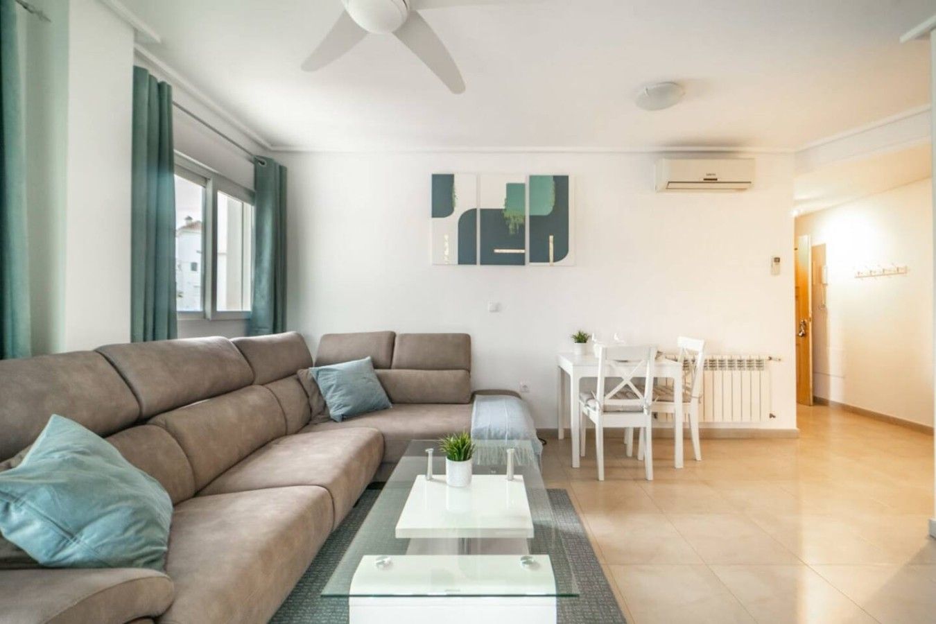 Een moderne woonkamer met een bank, salontafel en een eethoek.