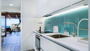 Una cucina moderna con un'isola grande, elettrodomestici in acciaio inossidabile e vista sull'esterno.