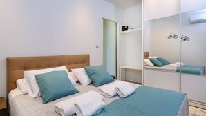Una camera d'albergo con un letto, cuscini, uno specchio e uno scaffale con una decorazione a forma di bicicletta.