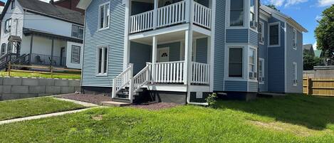 A two-story house with a balcony and a front porch.