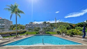 A rectangular swimming pool with a clear blue water, surrounded by a paved deck. - Faro Penthouse | Beachfront with Stunning Views (Maunabo)