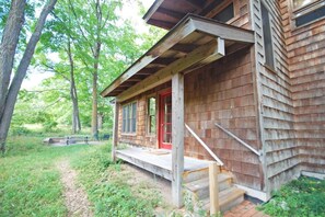 A wooden cabin with a porch, steps, and a red door. - Dune Path -  with Waterfront! (Empire)