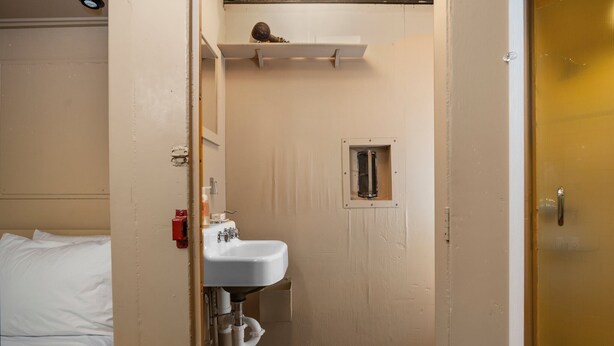 Un baño pequeño y funcional con un lavabo blanco, un espejo y una zona de ducha.
