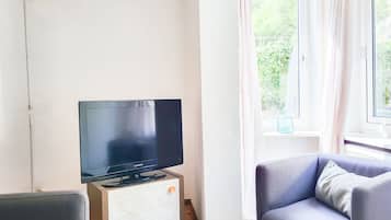 Standaard appartement, op benedenverdieping | Woonruimte | Een 32-inch flatscreentelevisie met digitale zenders en Netflix