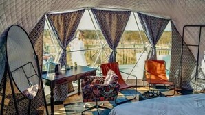 A tented accommodation with a checkered floor, a bed, a table, and two chairs. - Chateau Vartsikhe  (Baghdati)