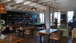 A spacious room with a pool table, bookshelves, and a cozy seating area. - Chateau Vartsikhe  (Baghdati)