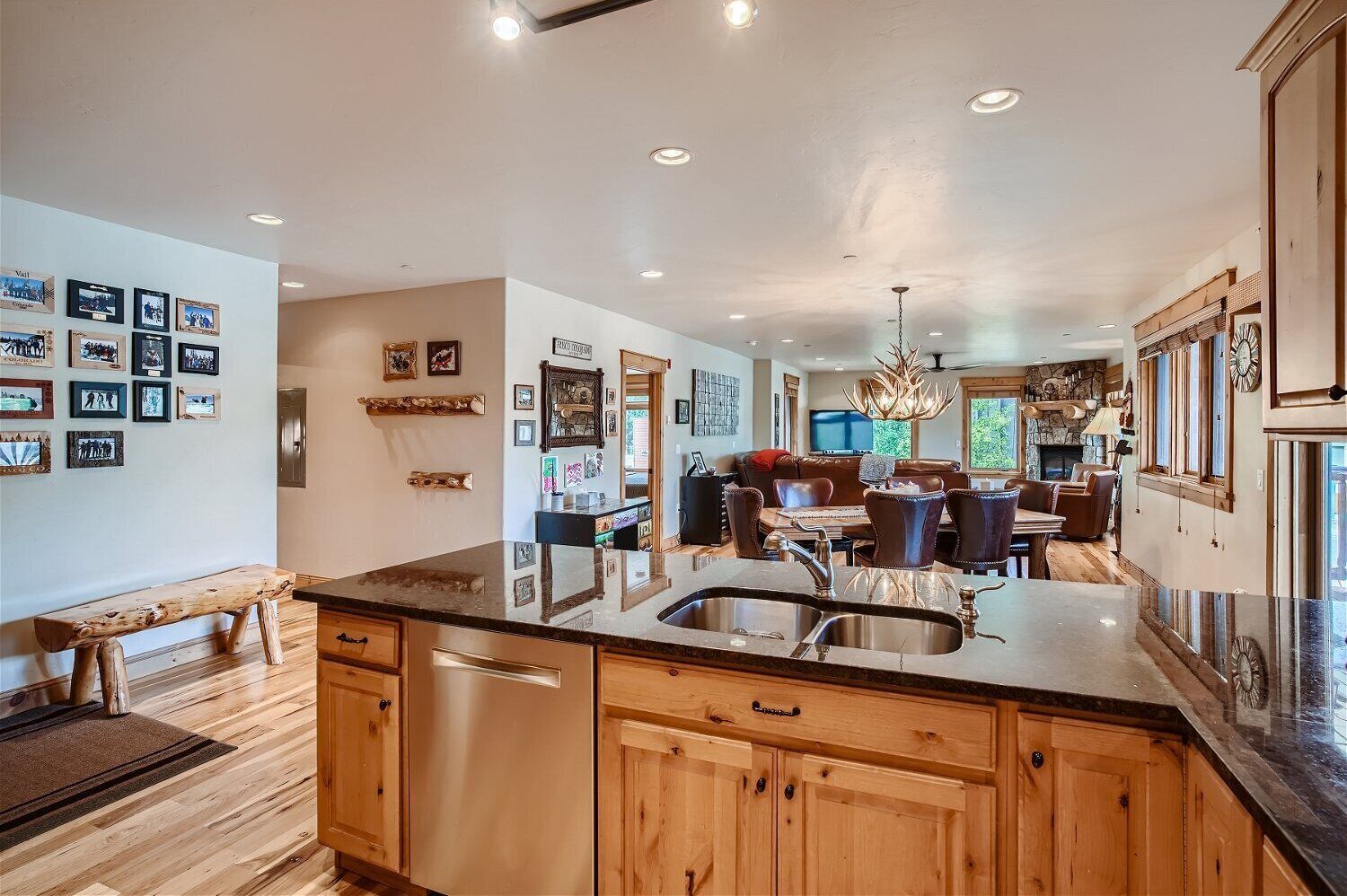 A spacious kitchen with wooden cabinets, a large island with a sink, and a dining area with a fireplace.
