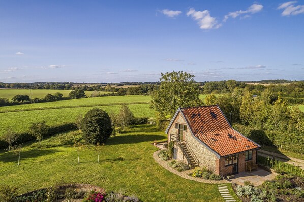 Une maison avec un toit en pente, des murs en pierre et un petit porche.
