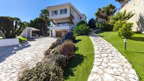 Una casa moderna de dos pisos con un sendero de piedra que lleva a la entrada.