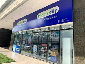 A pharmacy with a blue sign and large glass windows displaying various products.