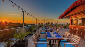Un espacio de comedor al aire libre con mesas y sillas, con vistas panorámicas.