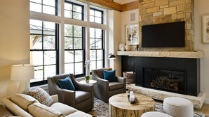 Una sala de estar acogedora con chimenea, asientos cómodos y ventanas amplias.