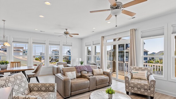 A spacious living room with a large sectional sofa, a round coffee table, and a ceiling fan. - Across the Pond | Private Pool + Near Beach (Surf City)