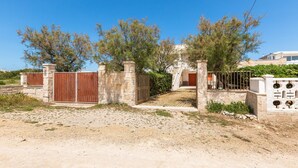 A gated property with a stone wall and a wooden gate.