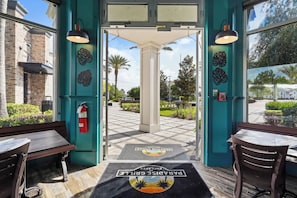A hotel entrance with a fire extinguisher, a bench, and a table.