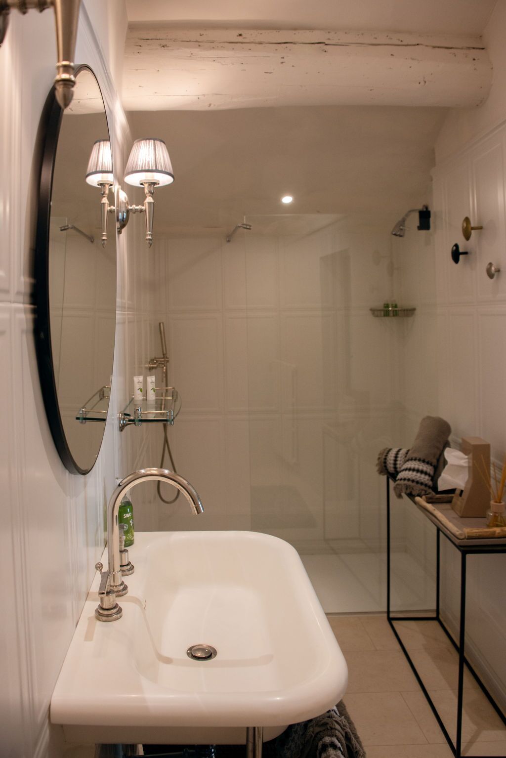 A bathroom with a white sink, a mirror, and a shower.