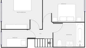 Un plan d’étage d’un hôtel comprenant une chambre principale, deux chambres standard, une salle de bain, un hall et un escalier.