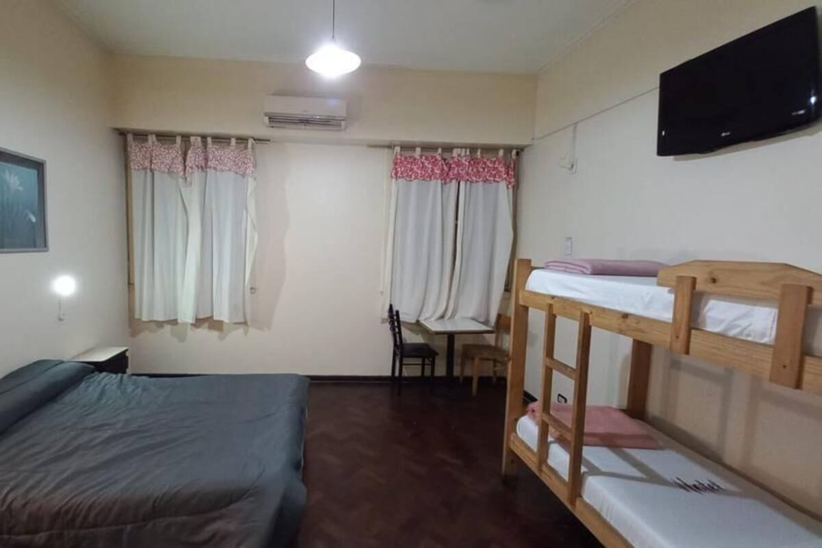 A room with a bed, a desk, and bunk beds.
